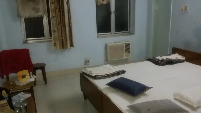 A guest room with an air-conditioner and a double bed