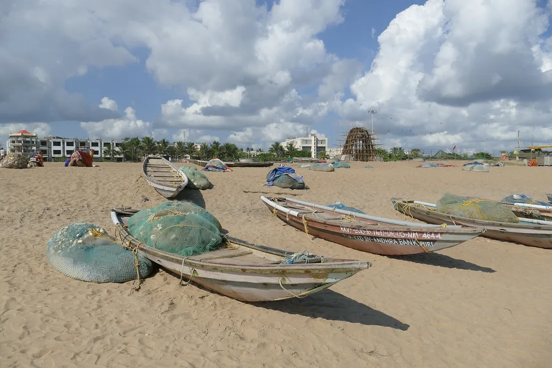 The wide sand of Puri beach under an overcast sky